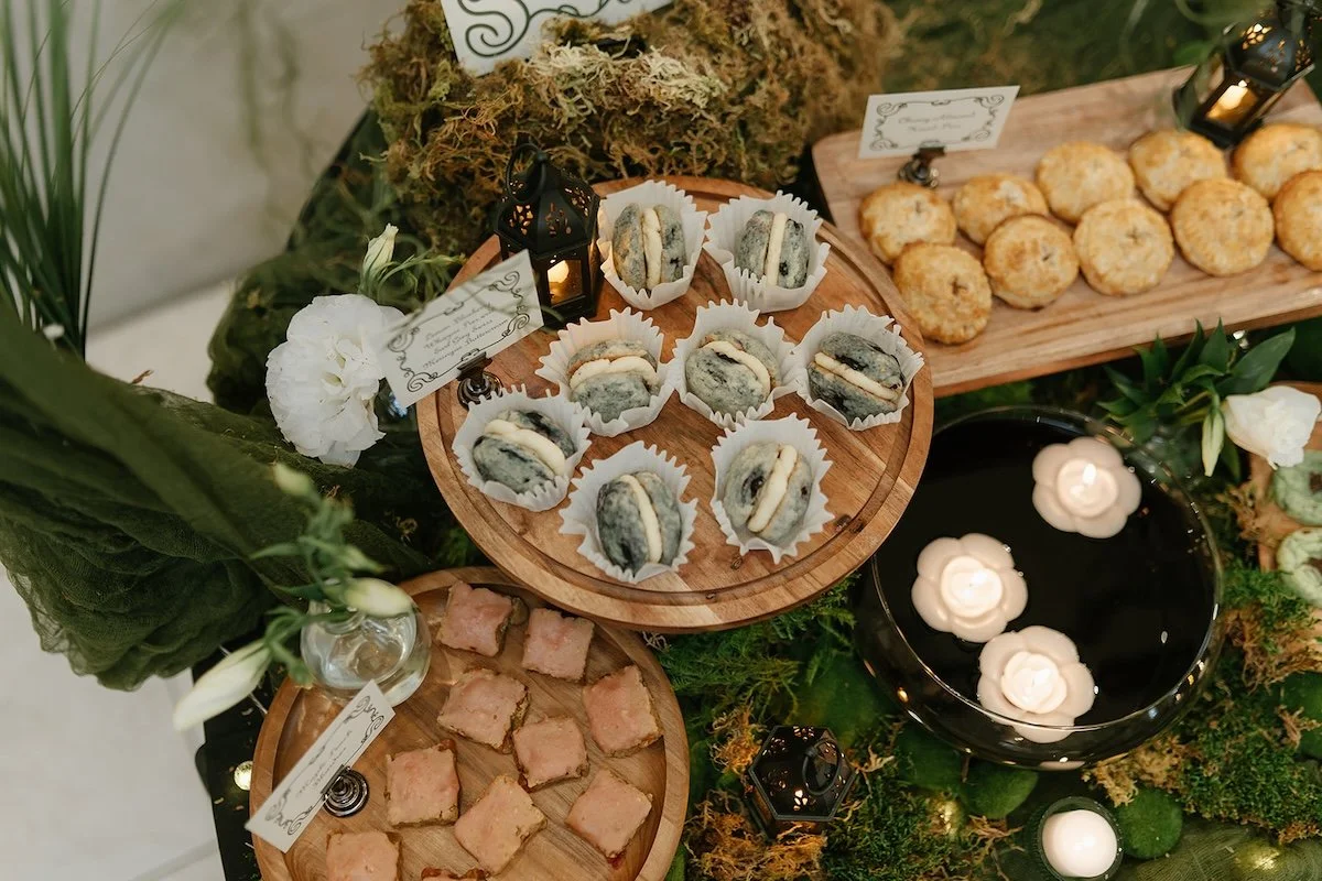 overhead shot of a dessert table spread with lanterns, florals, and greenery