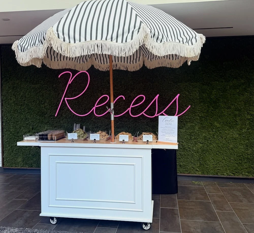 Cookie cart with greenery wall in background