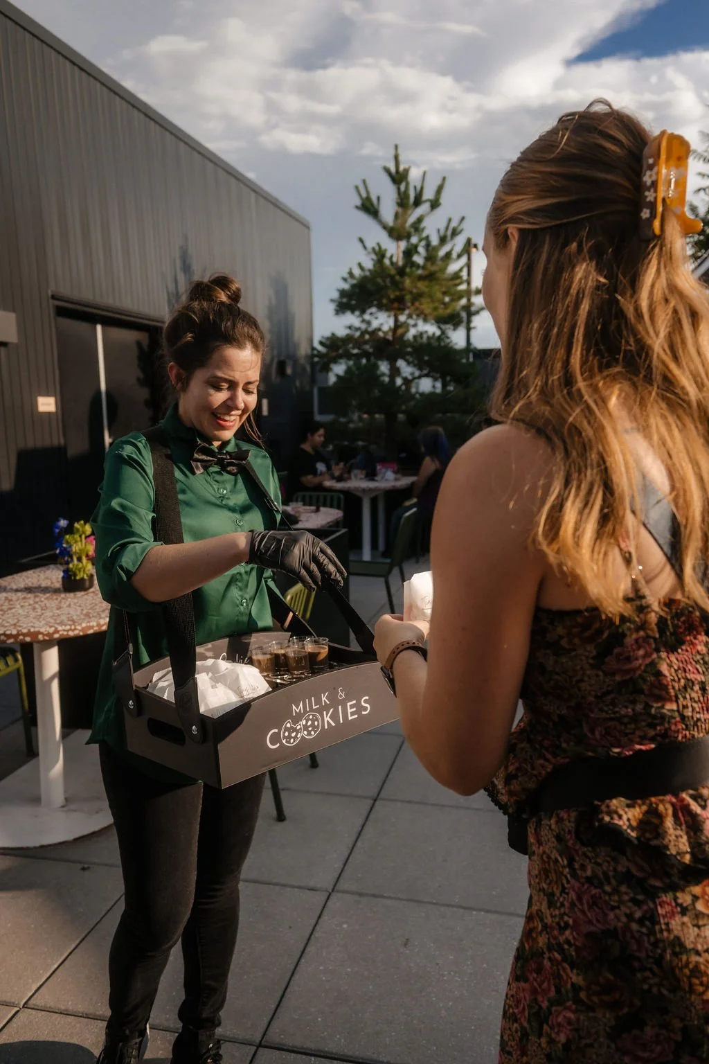 Server passing around a cookies and cold brew coffee shots