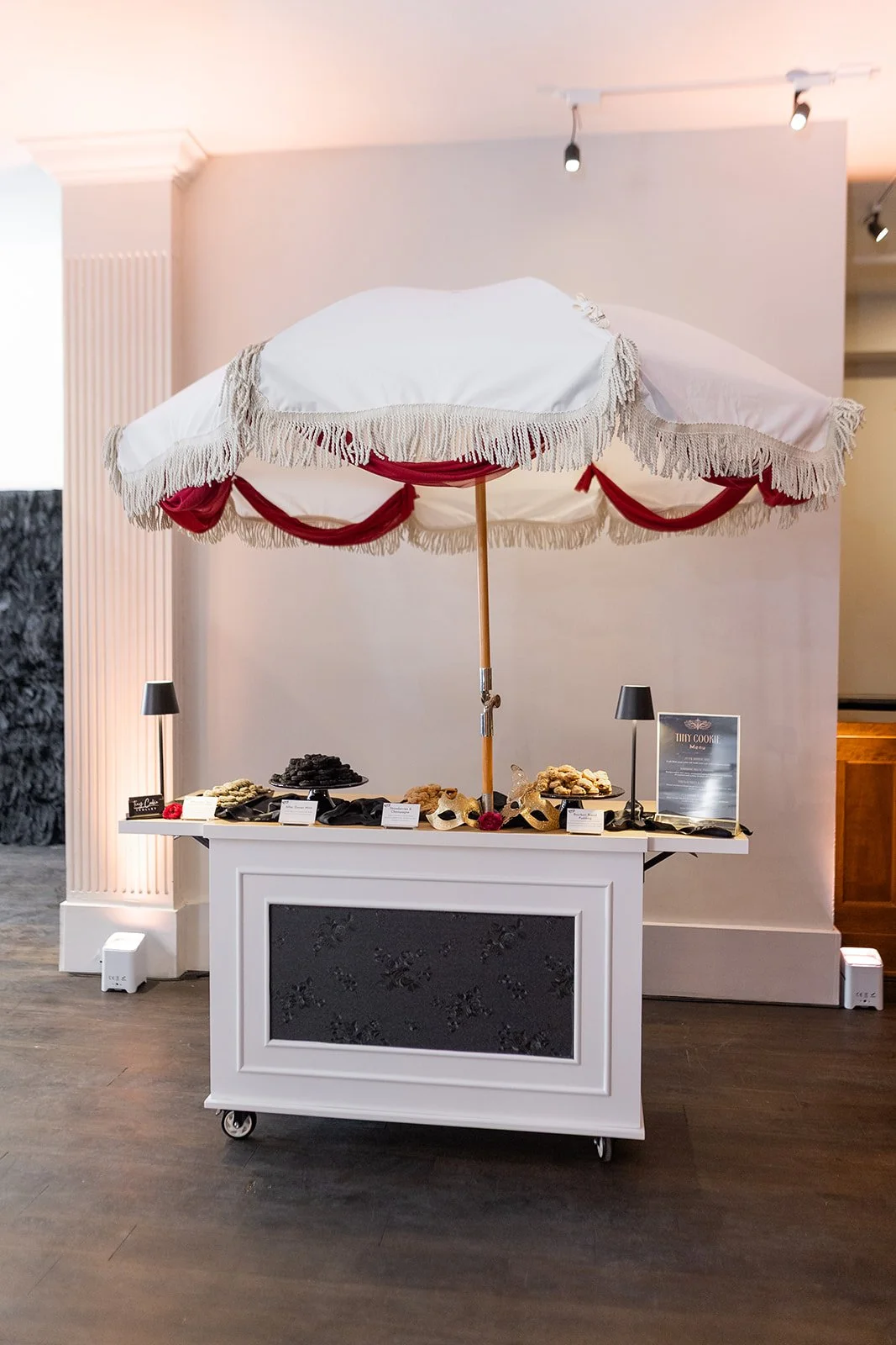 Dessert cart with white umbrella and moody decor