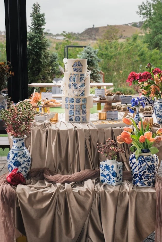 Elevated wedding dessert table styled with blue and white chinoiserie vases, tulips, hand pies, lemon elderflower bars, and matcha rice krispies by The Tiny Cookie Trolley, Denver dessert catering