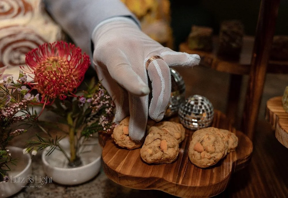 Close up of a gloved hand reaching for tiny cookies