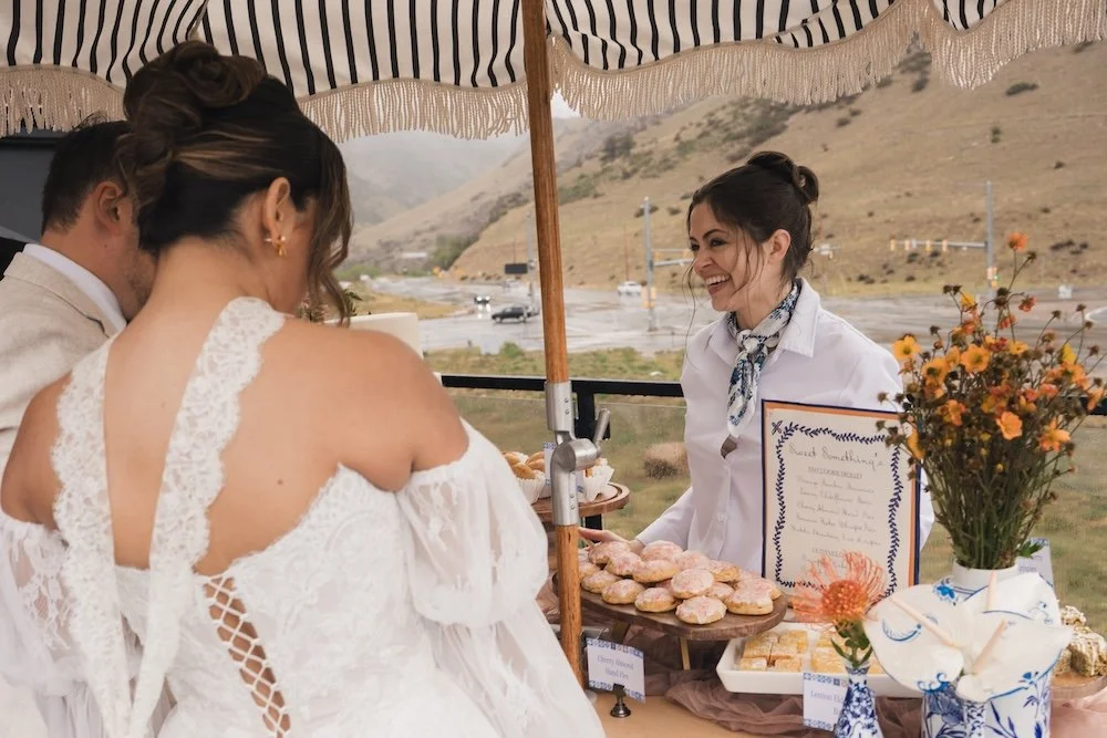 Bride and groom at a dessert cart looking over their choices