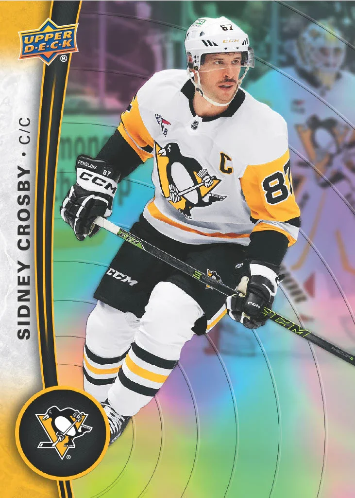 A hockey player in a white, yellow, and black uniform with the number 87 and a captain's 'C' on his jersey, holding a hockey stick on the ice. The player's helmet and gloves are branded CCM. The background has a rainbow-colored swirl design, and the 