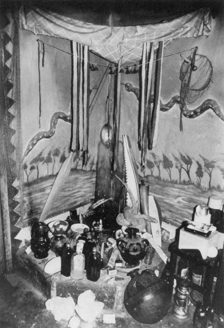 'An aquamarine shrine environment recreating Mami Wata's underwater world with fishnets, canoe paddles, and a stuffed, coiled snake which the possessed medium wraps around her neck and holds aloft in her right hand in imitation of the snake charmer p