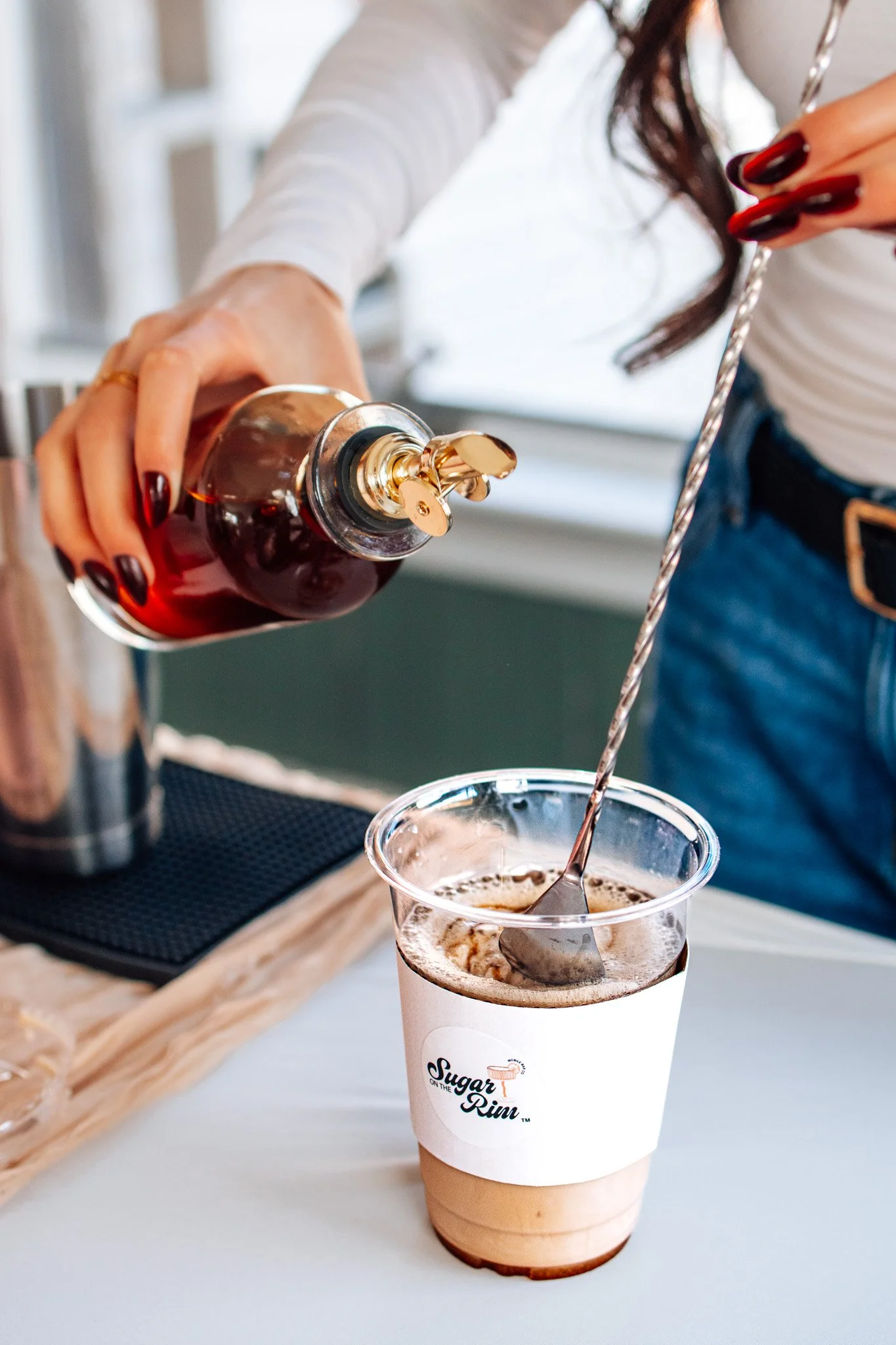 Three women holding dessert cups, one wearing lace bunny ears, smiling indoors.