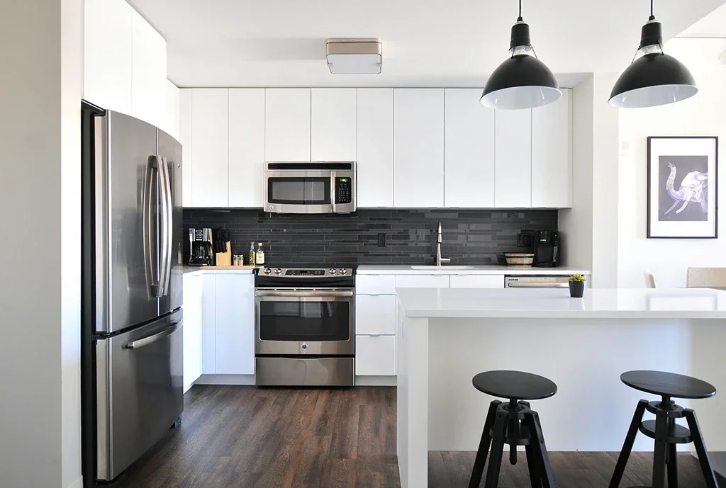 A bright and modern kitchen with wooden flooring and grey appliances. The underfloor insulation keeps the floor comfortable.