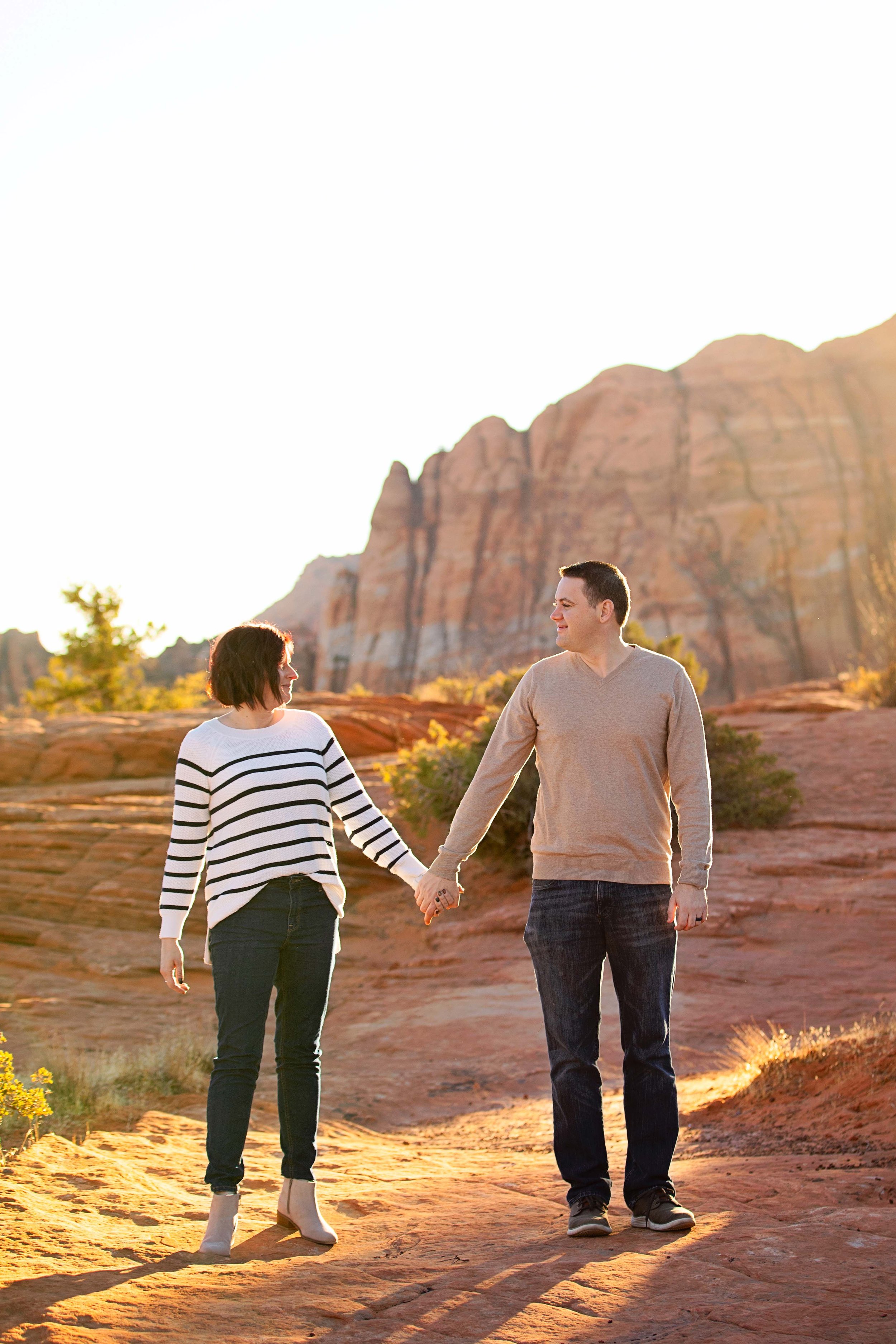 Mom-and-dad-holding-hands-during-family-session-in-Snow-Canyon,-UT