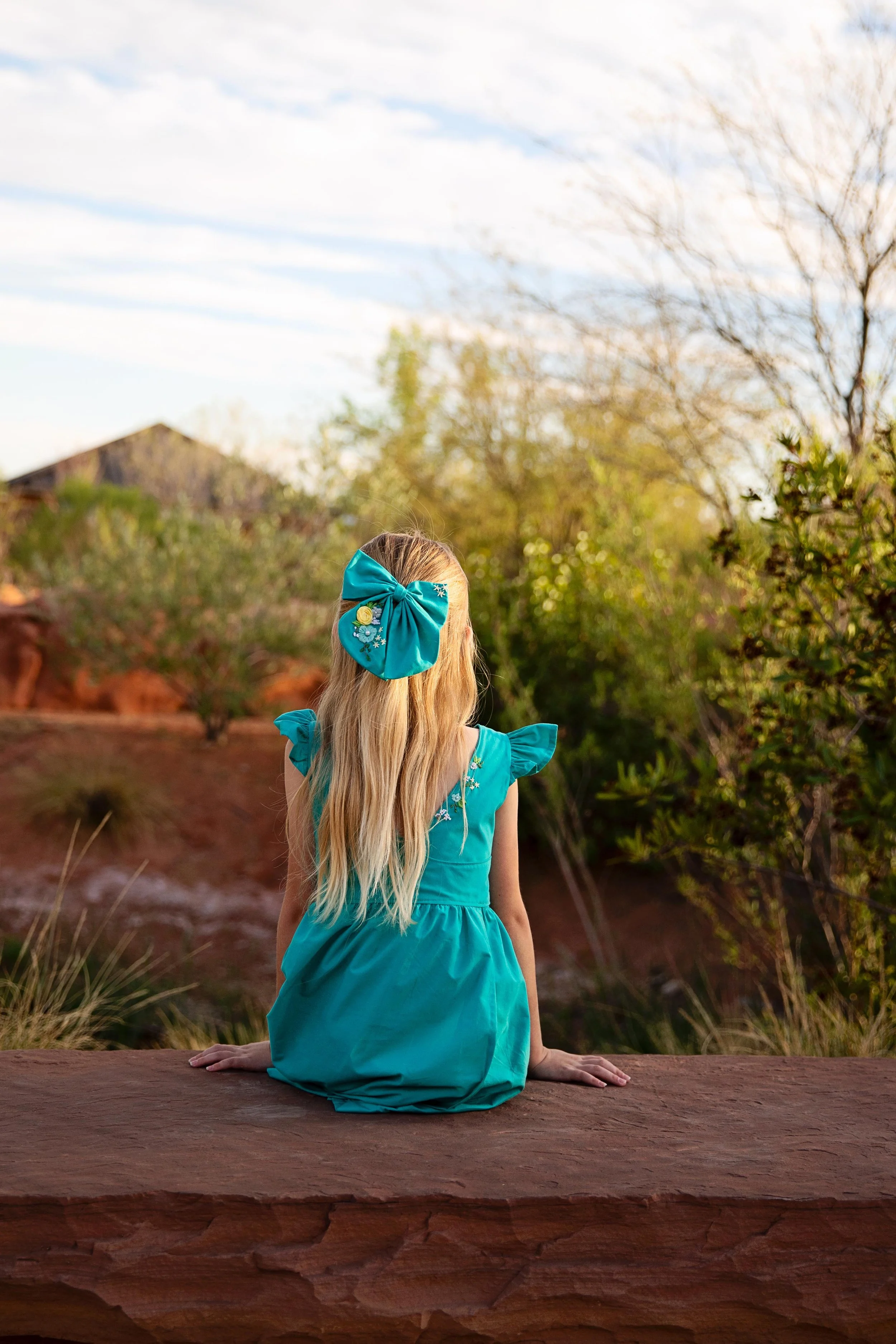 Girl_sitting_red_hills_desert_garden.jpeg