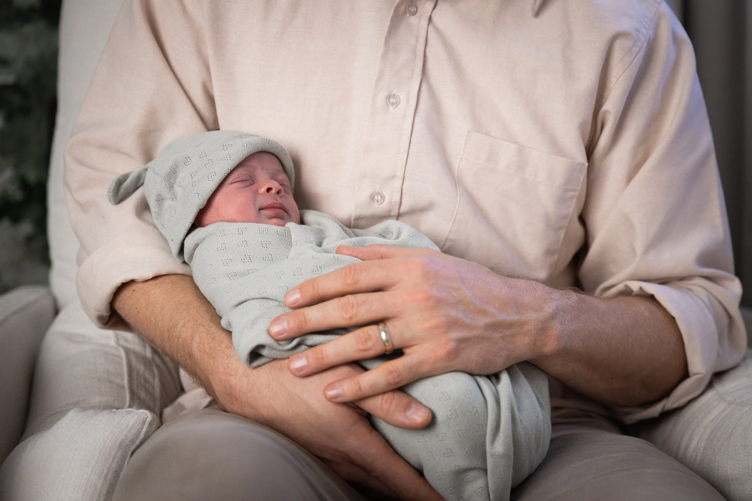 father holding baby boy durning newborn session