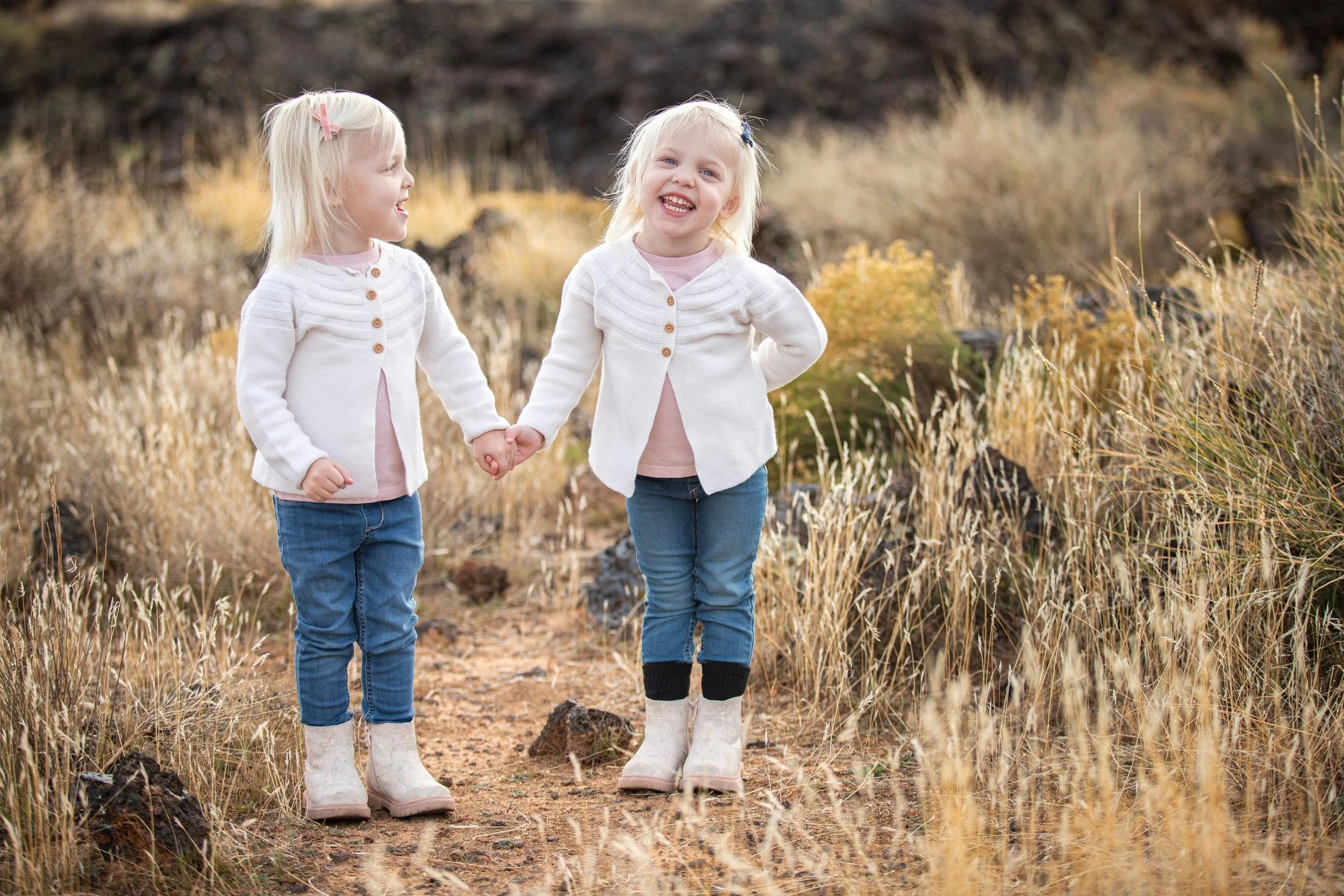 Ivins Utah photographer - twin girls posing in grassy fall desert lava fields.