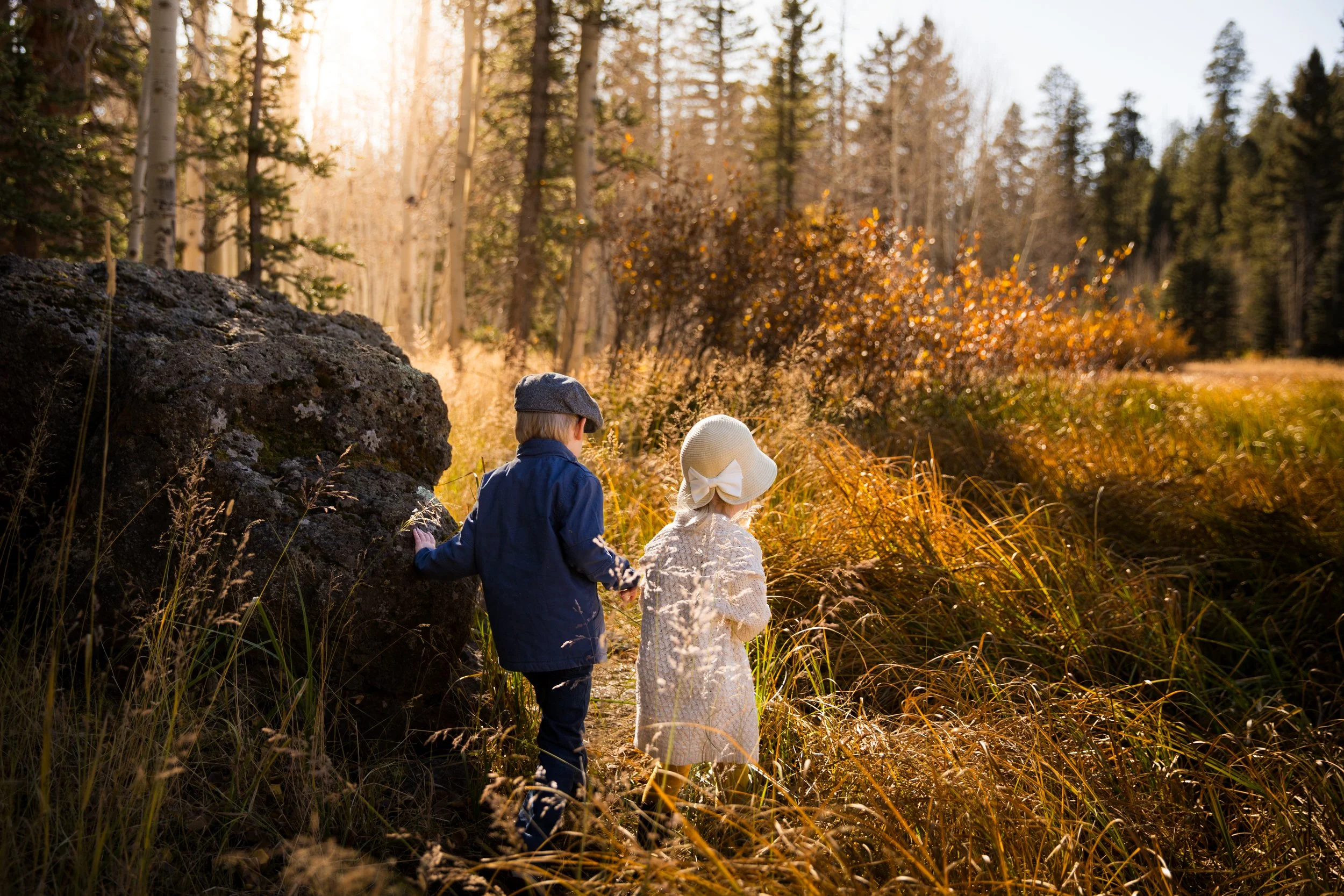 Two siblings hiking through fall foliage in Cedar mountain Utah during cinematic portrait session.