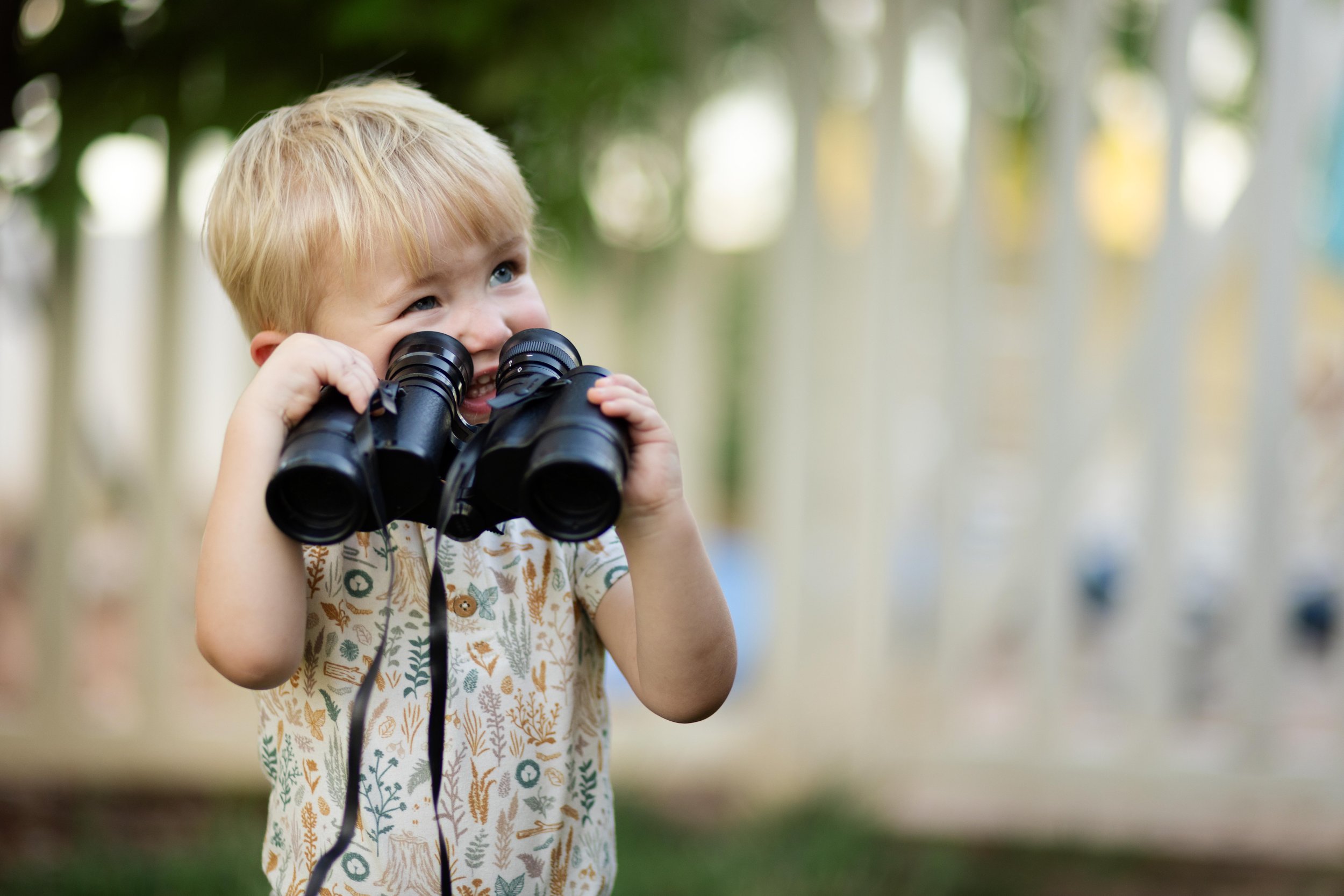 Deep and moody photo toddler clumsily looking through binoculars during Everyday Magic portrait session with My Deer Little Fox | Photography by Kayla Stewart in Southern Utah.