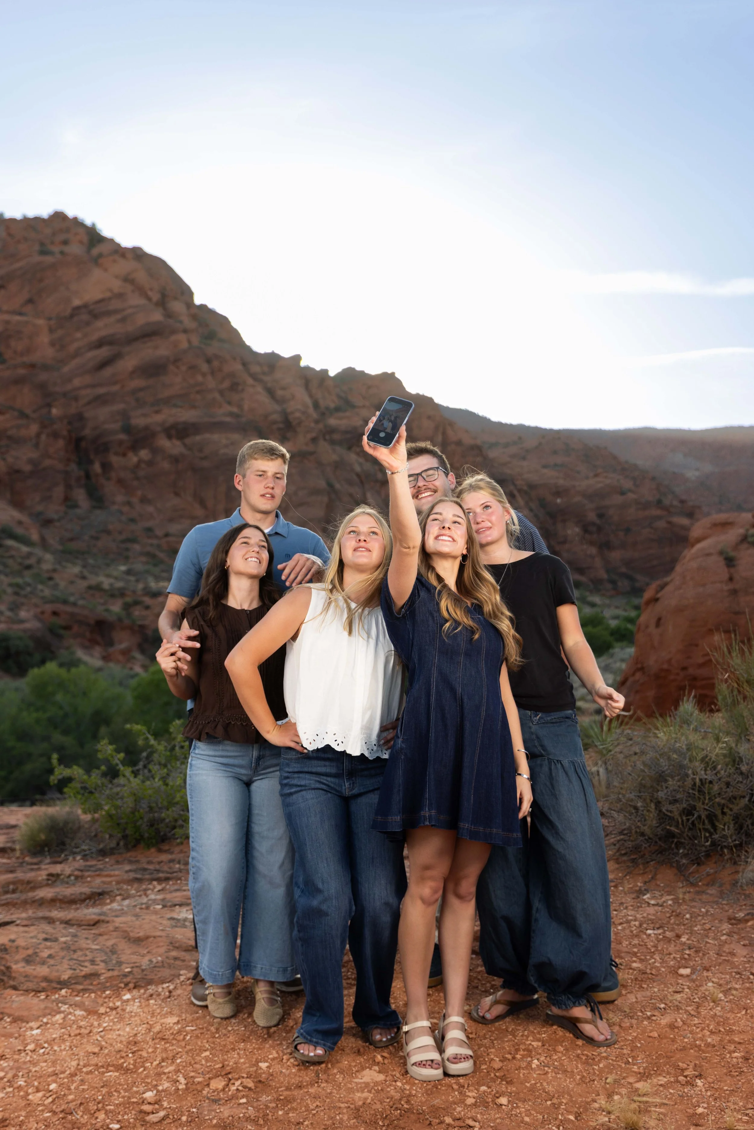 adult siblings taking a selfie together during extended family photos in southern Utah.
