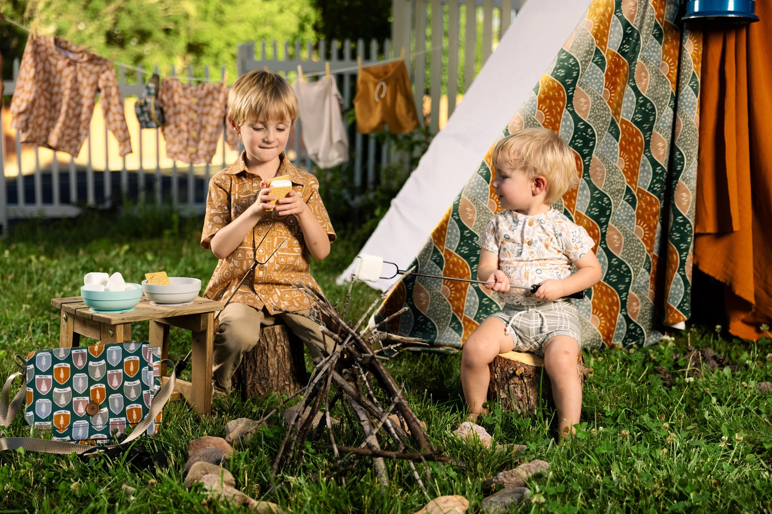 Deep and moody Backyard Lifestyle camping themed photo of two boys pretending to roast marshmallows in St. George Utah.