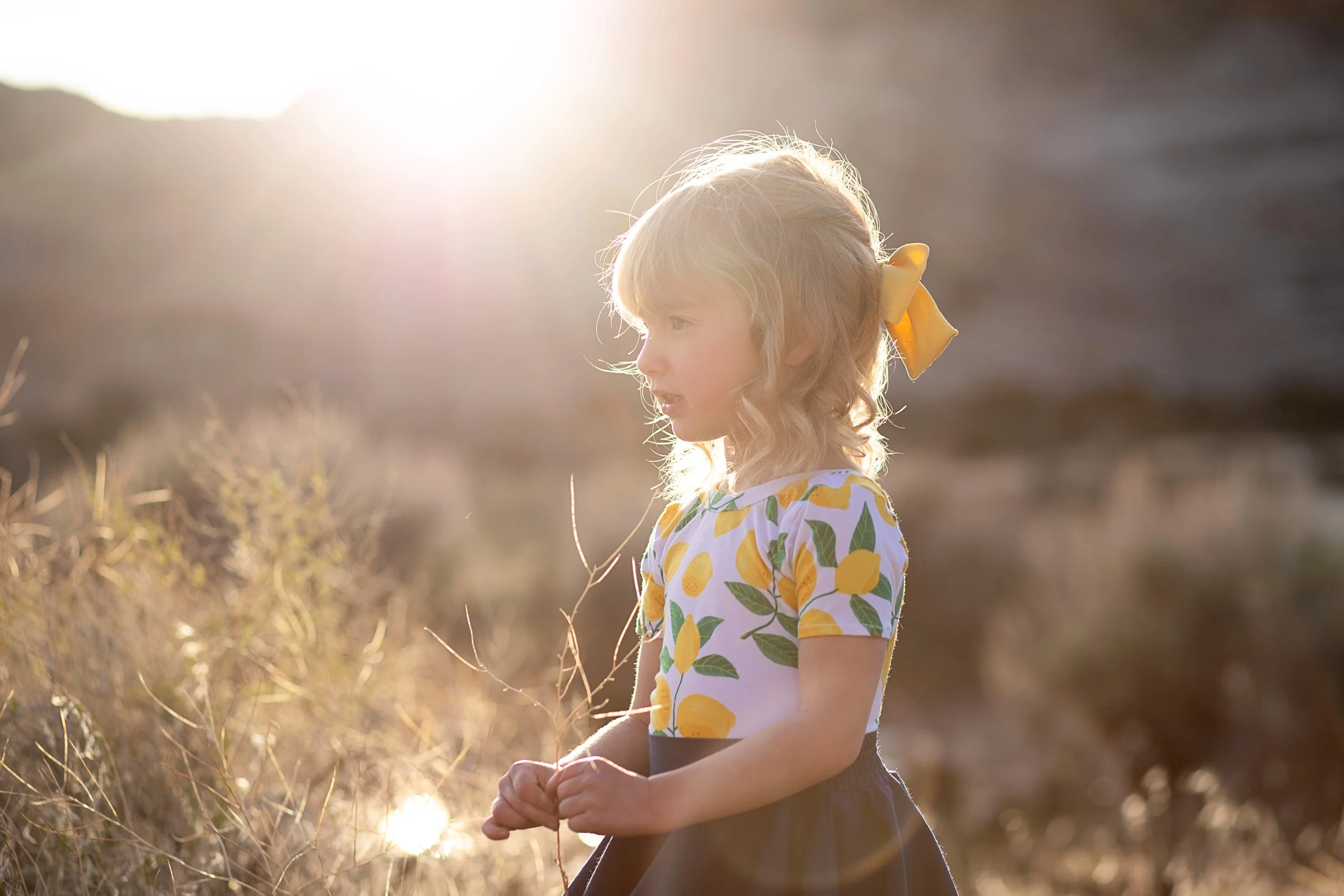girl standing holding a stick during golden hour in Snow Canyon in the summer