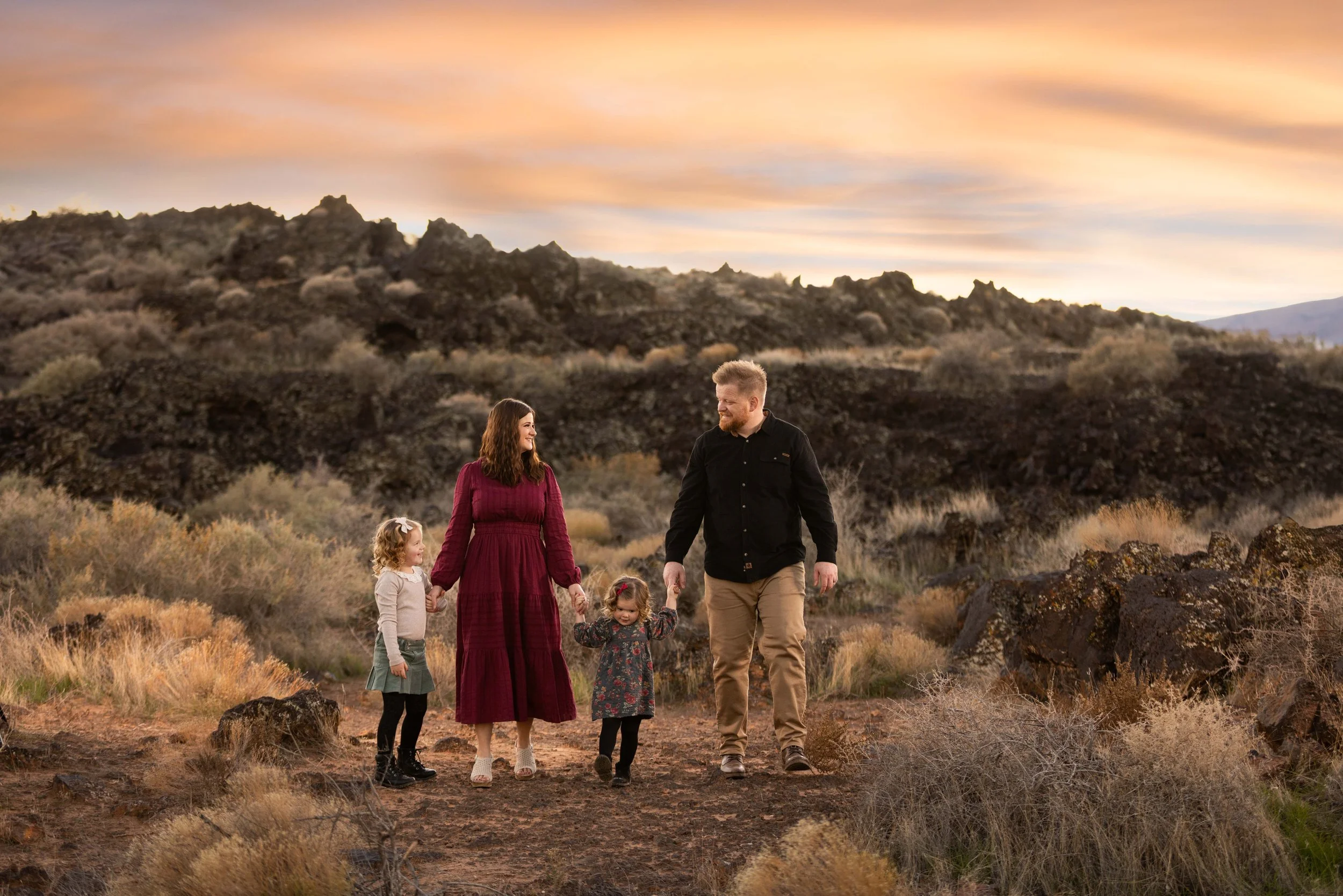 Soft pink sunset light surrounding parents and their kids during epic family photo session in St. George Utah.