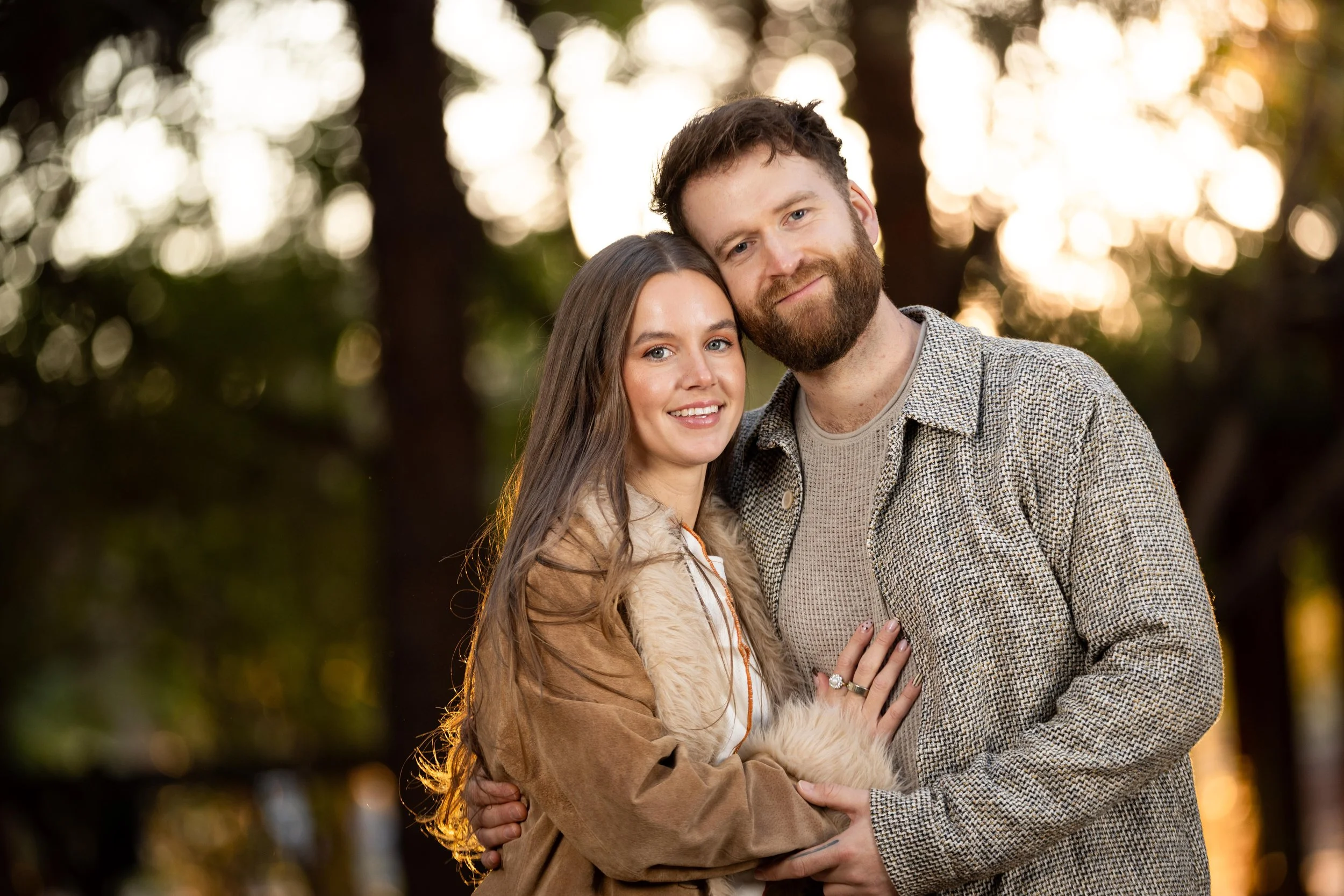 Couple cuddled close looking at camera during cinematic engagement session in southern utah.