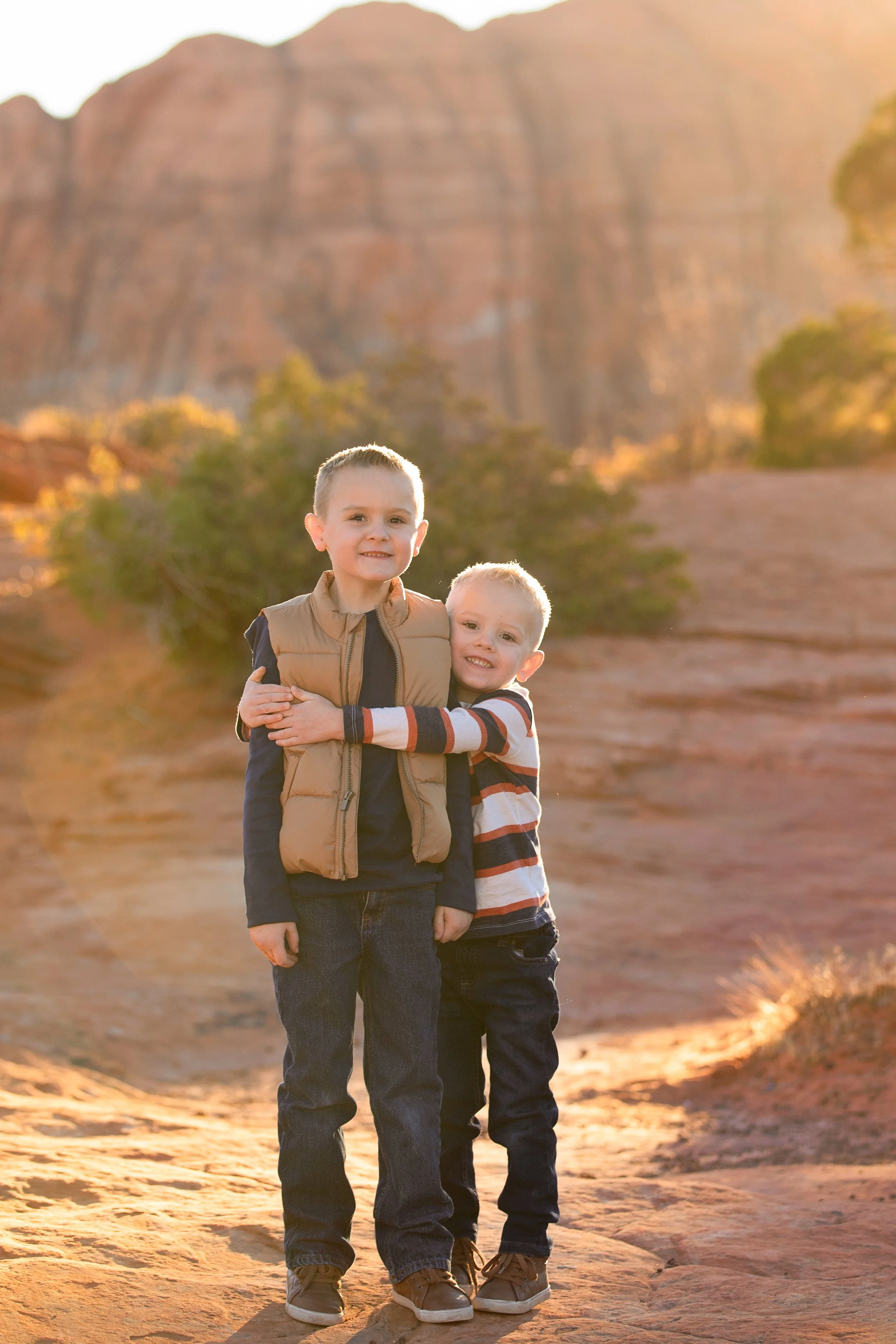 Brothers hugging during family photos in snow canyon.