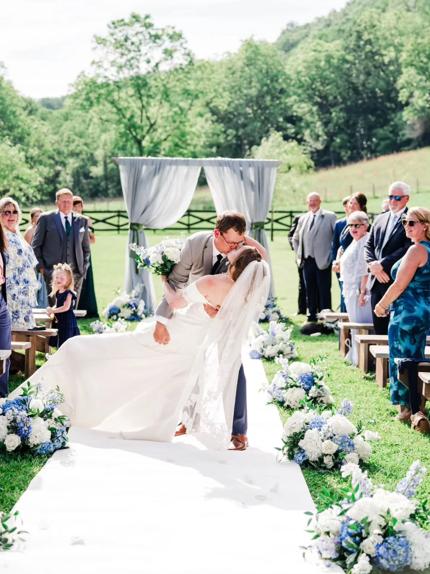 Eleanor &amp; Nick had the most gorgeous day! The blue and green color pallette with floral accents was just perfect. The floral lined aisle was so gorgeous by the pastures. Their sweet pup Holmes was the ring Bearer and he definitely stole the show!