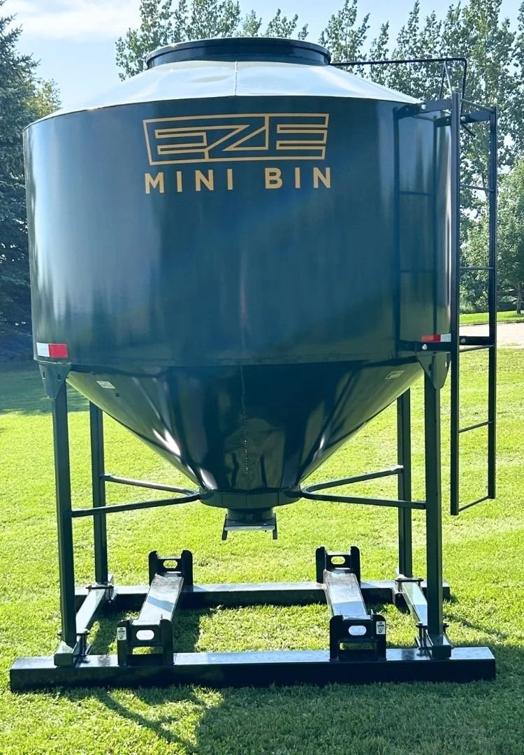 Front view of a 95 bushel green feed storage win with black metal side ladder , metal stand with fork pockets.