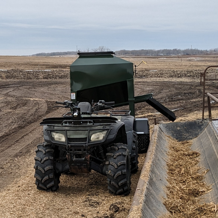 Eze-Feeder UTV15 small livestock feeder on trailer, pulled behind an ATV.