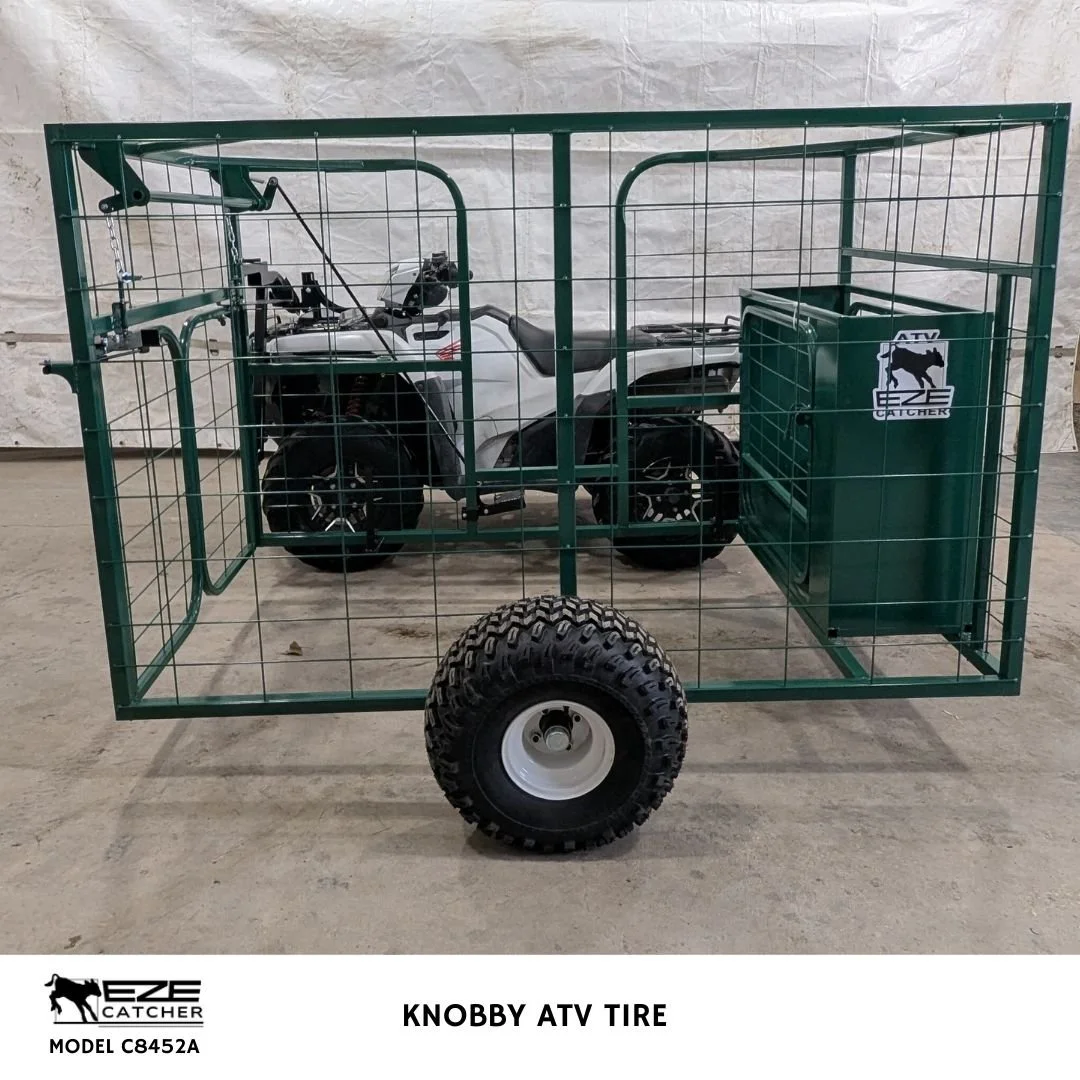 A side view of an Eze-Catcher calf catcher cage with knobby ATV tire attached to an ATV