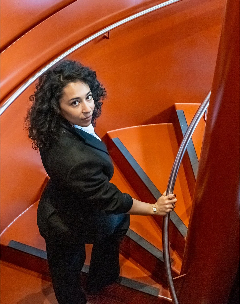 Liv walking up a red staircase