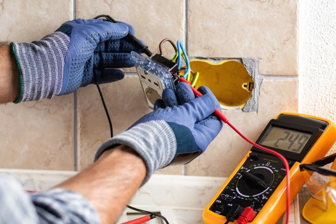 A tech working on the electricals of a power socket.