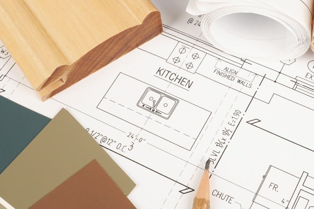 Architectural blueprint of a kitchen, showing a double sink and measurements, with sample paint swatches and a wooden trim.