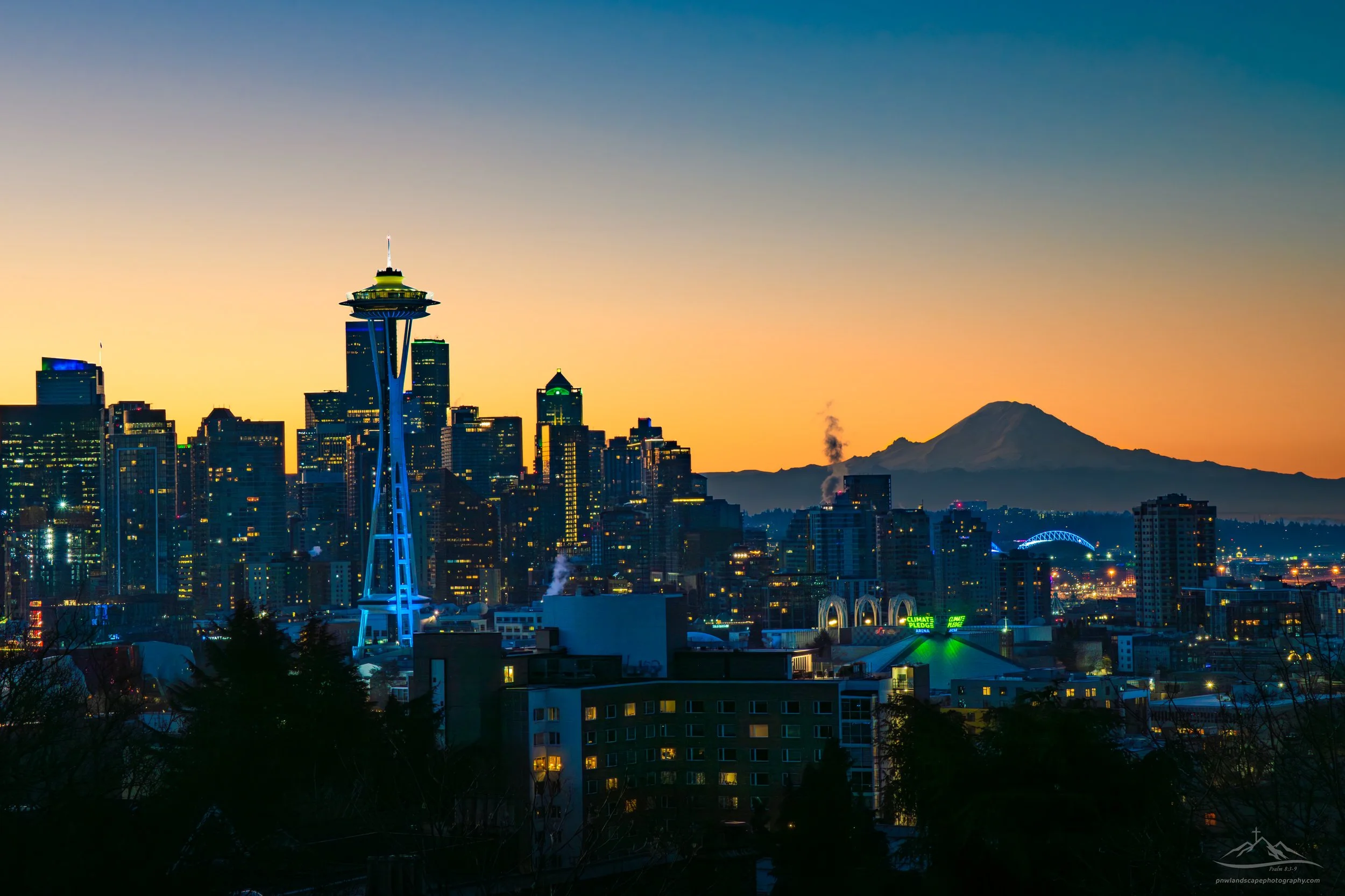 Seattle all dressed up in blue and green preparing for the big game. Simply a spectacular contrast of a bustling city with the sun rising over it's resident volcano. 