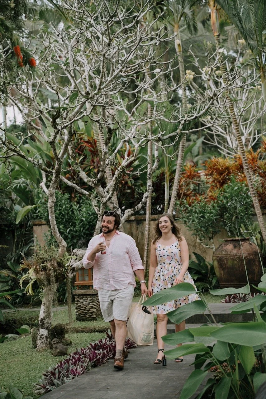 Wedding guests arriving through lush tropical garden pathway at Bali destination wedding.