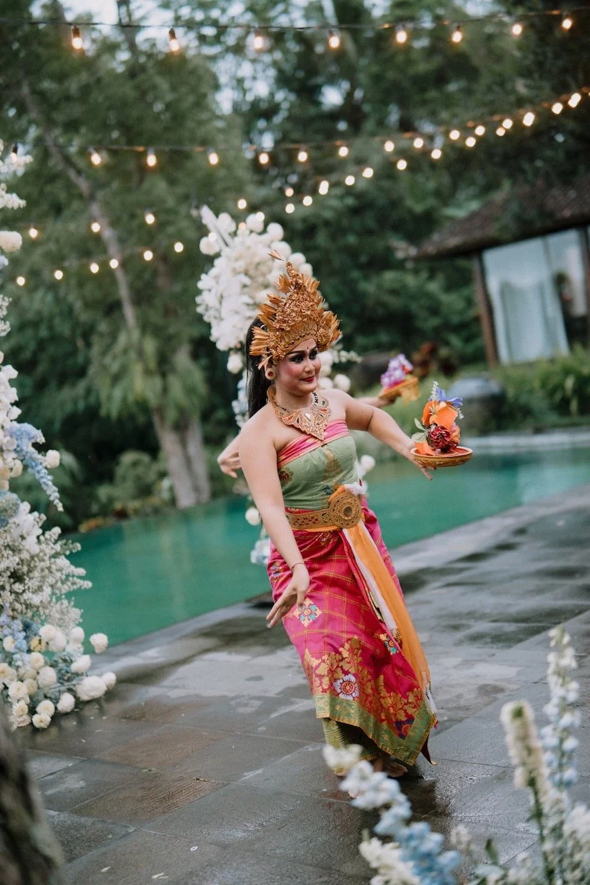Traditional Balinese dancer performing in vibrant ceremonial costume during destination wedding celebration in Bali.