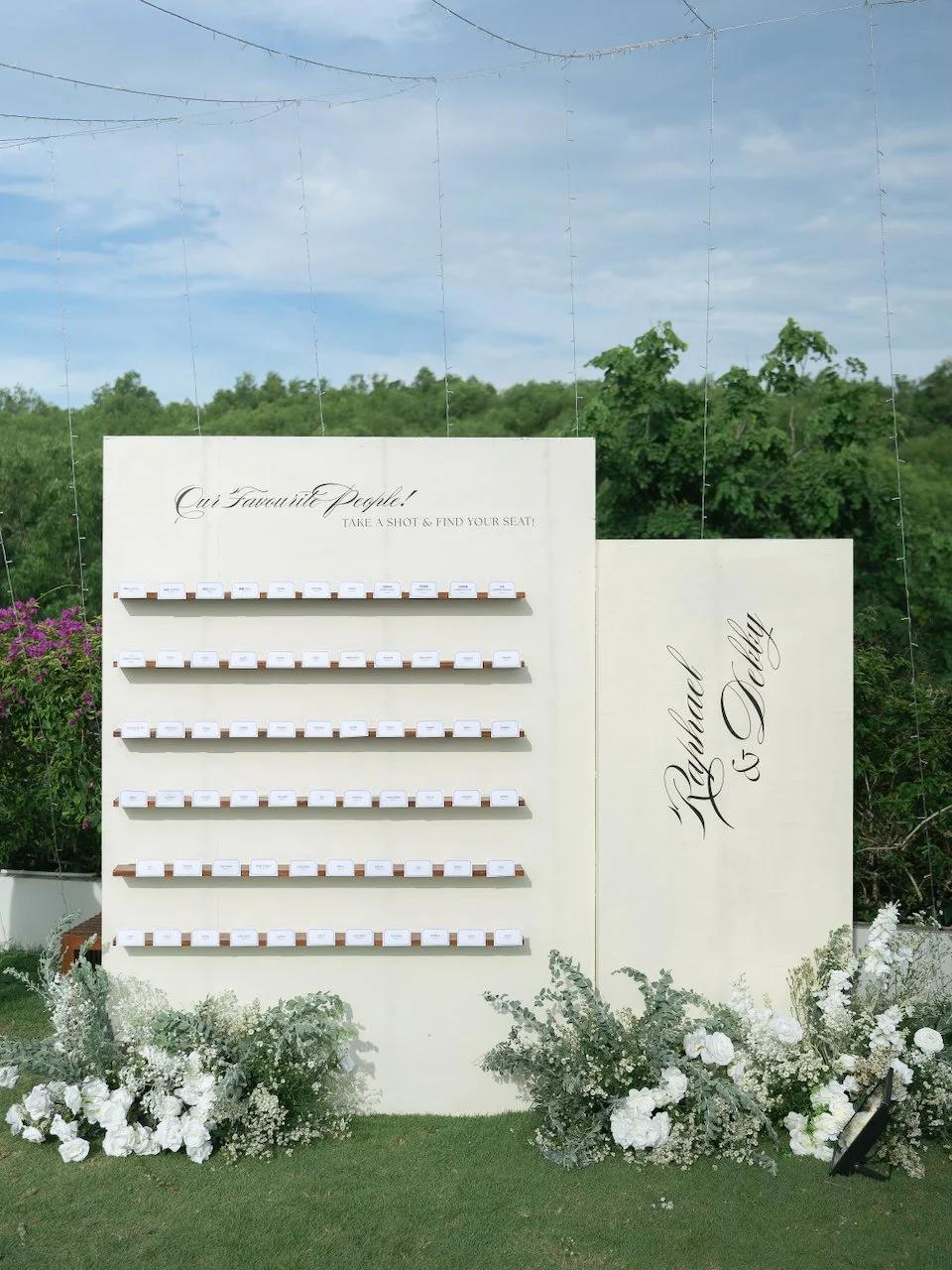 Custom wedding seating display styled with modern typography and white florals at a Bali destination wedding.