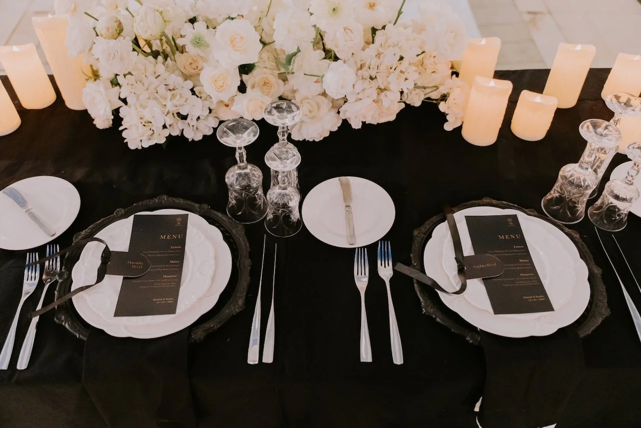 Close-up of white floral arrangements and candles lining the aisle at an elegant Bali wedding ceremony