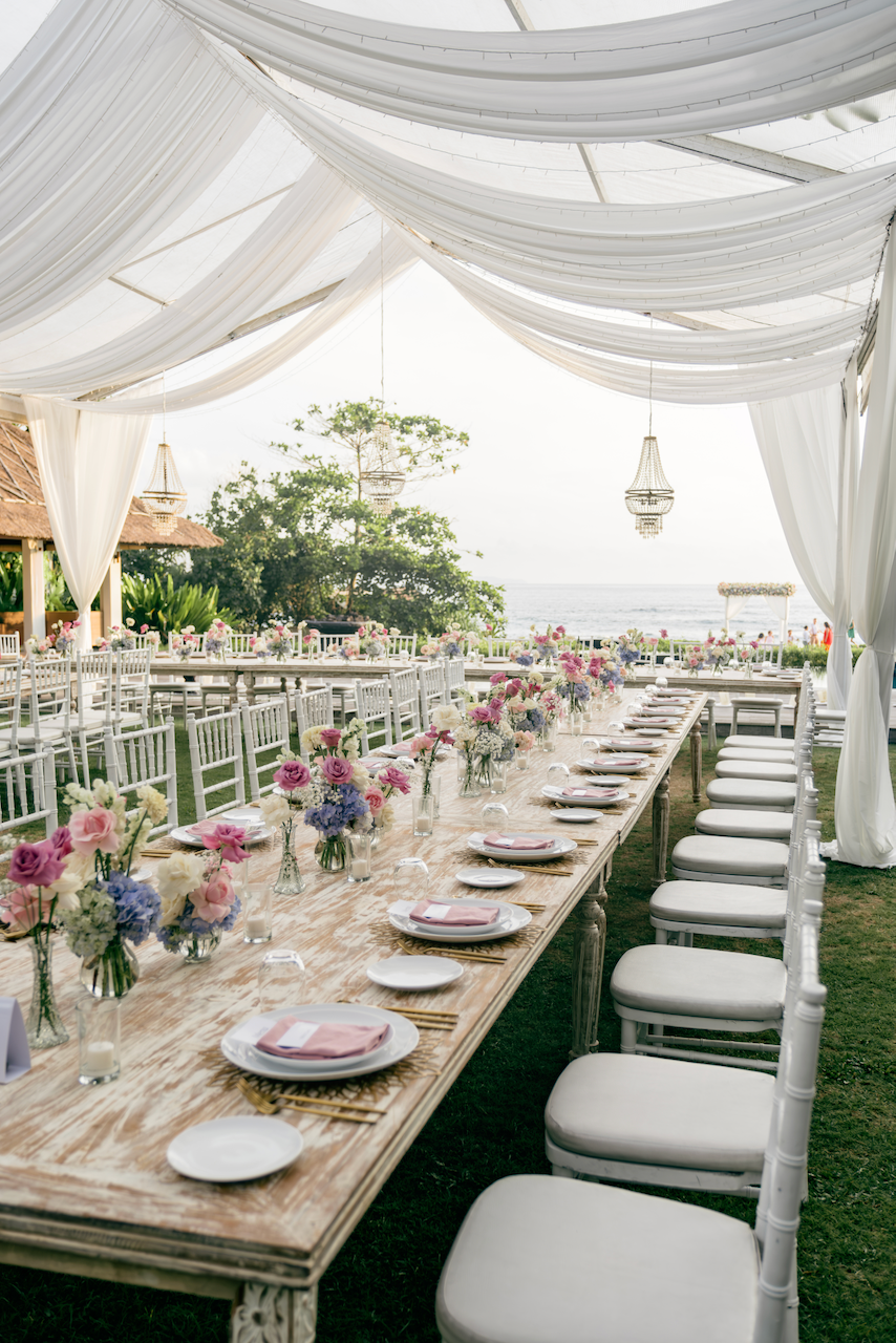 Elegant outdoor reception space with long wooden tables and canopy draping designed by Silver Lace Weddings