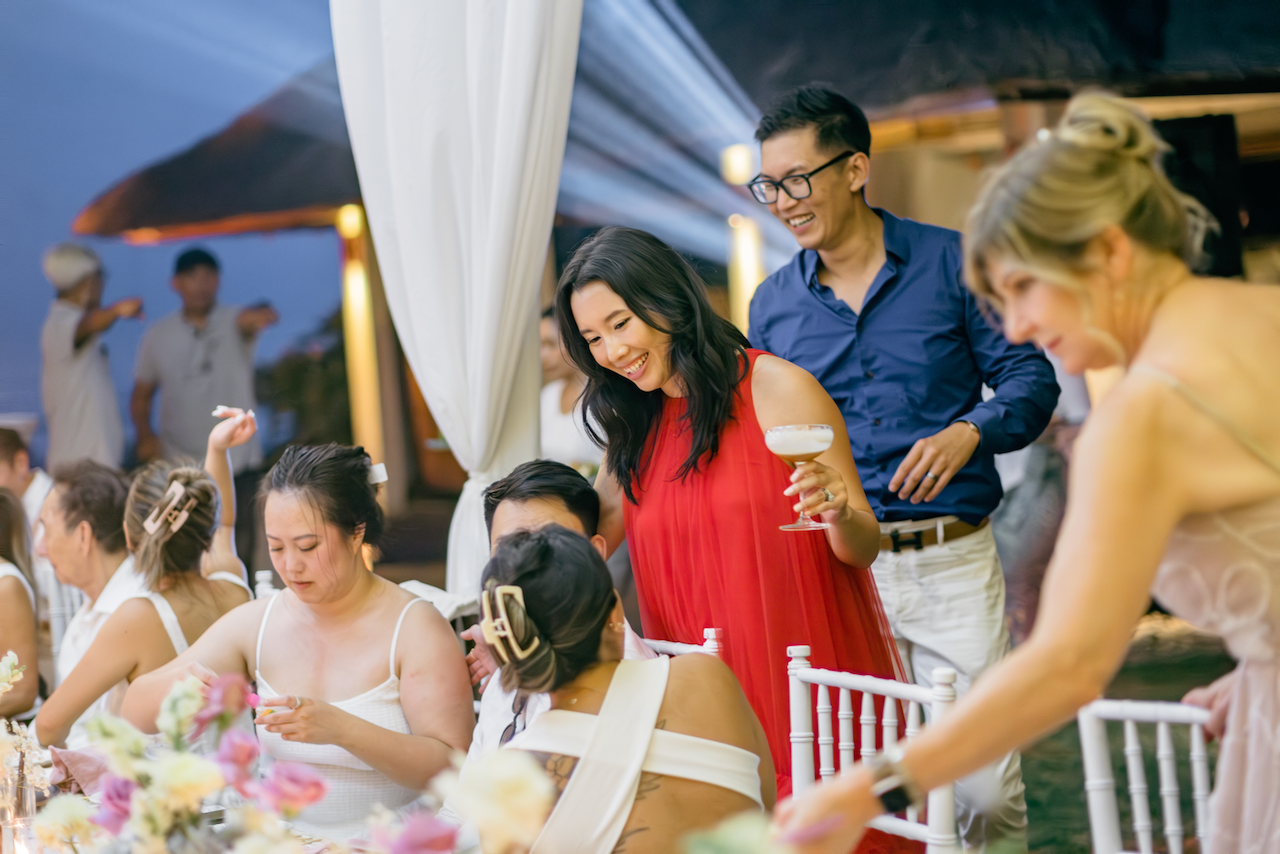 Bride in a red dress mingling with guests at a Silver Lace Weddings dinner reception