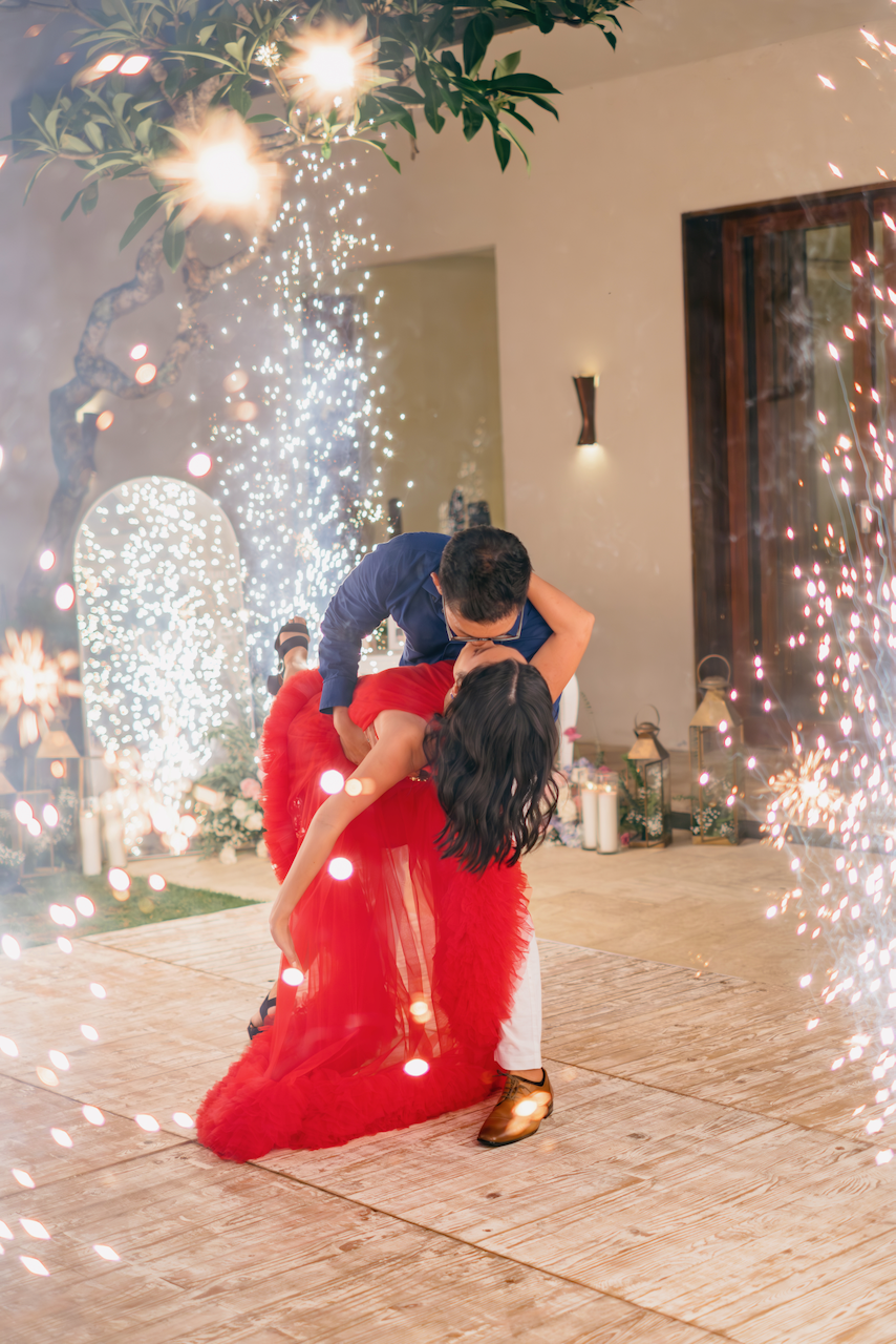 Groom romantically dipping the bride on the dance floor surrounded by cold sparklers at a Bali villa