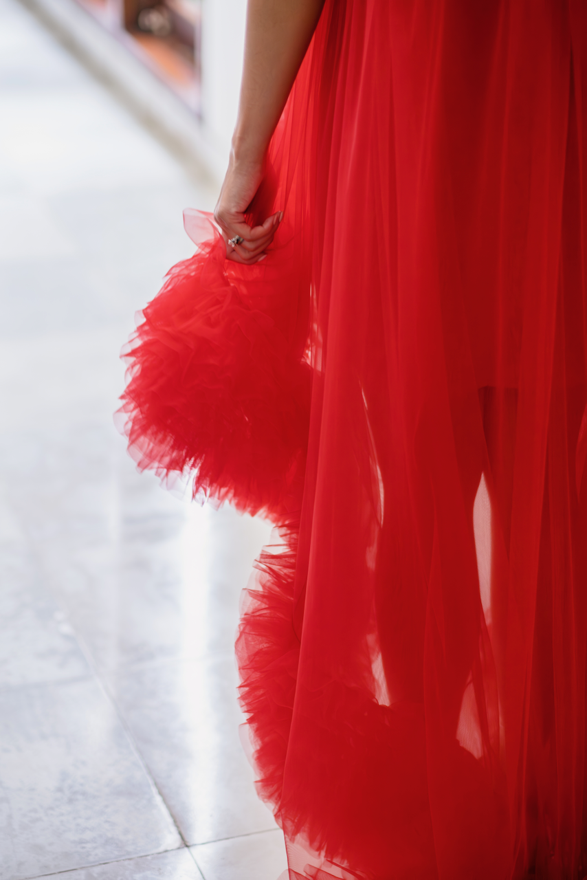 Close-up of the intricate red tulle ruffles of the bridal gown, a unique element of a Bali wedding