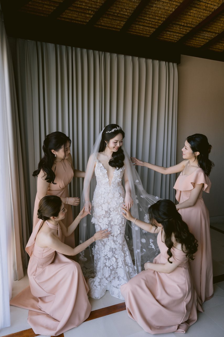 Bride in lace gown with bridesmaids during Bali villa wedding preparations