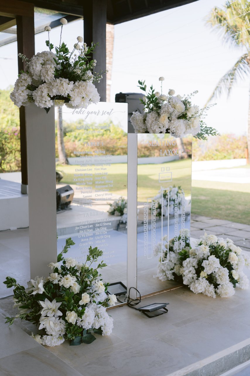Elegant wedding signage and seating chart with white flowers in Bali villa