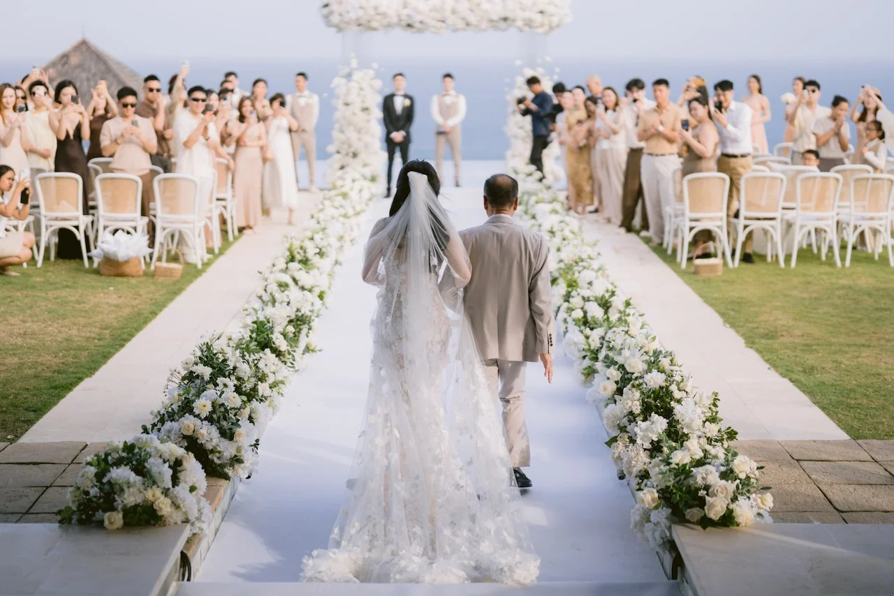 Guests watching bride walk down aisle at Bali destination wedding ceremony