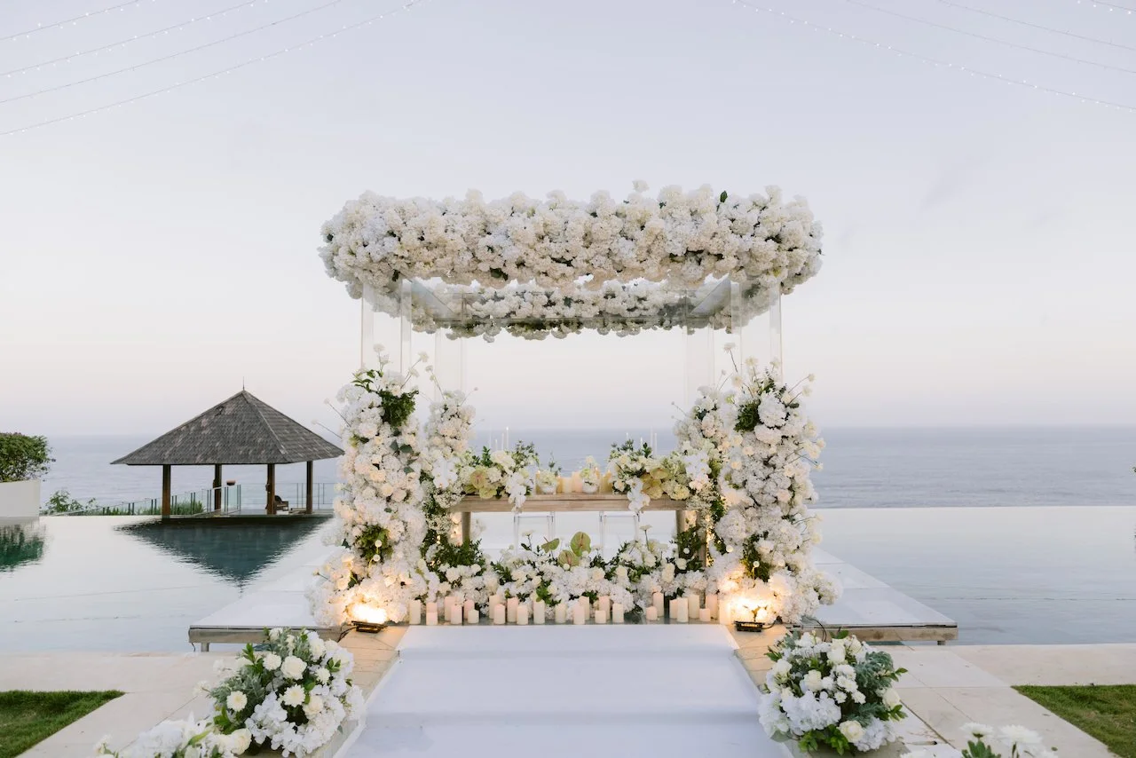 Floral reception stage with candles overlooking ocean at Surga Estate Bali