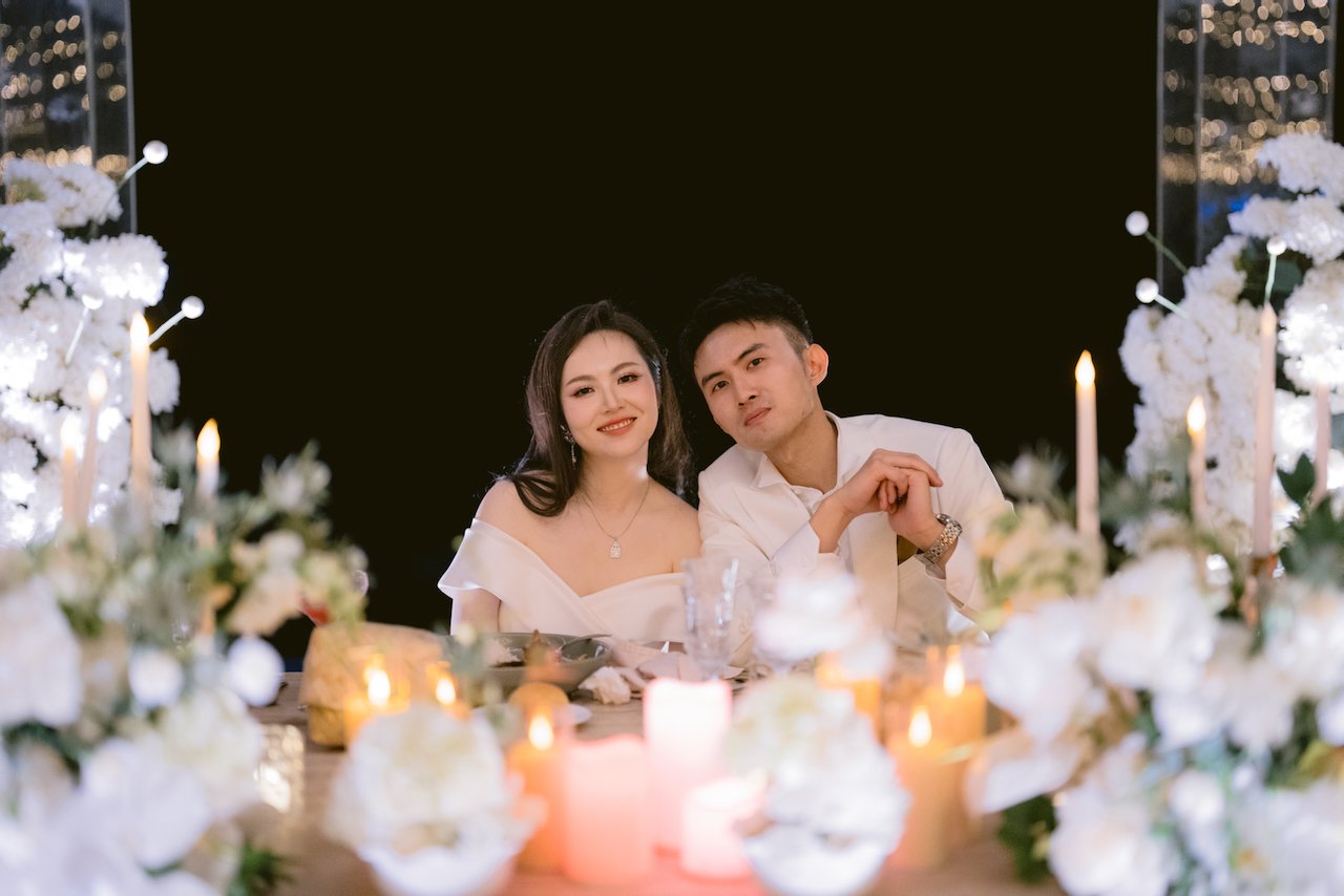 Newlyweds seated at candlelit table during Bali villa wedding dinner