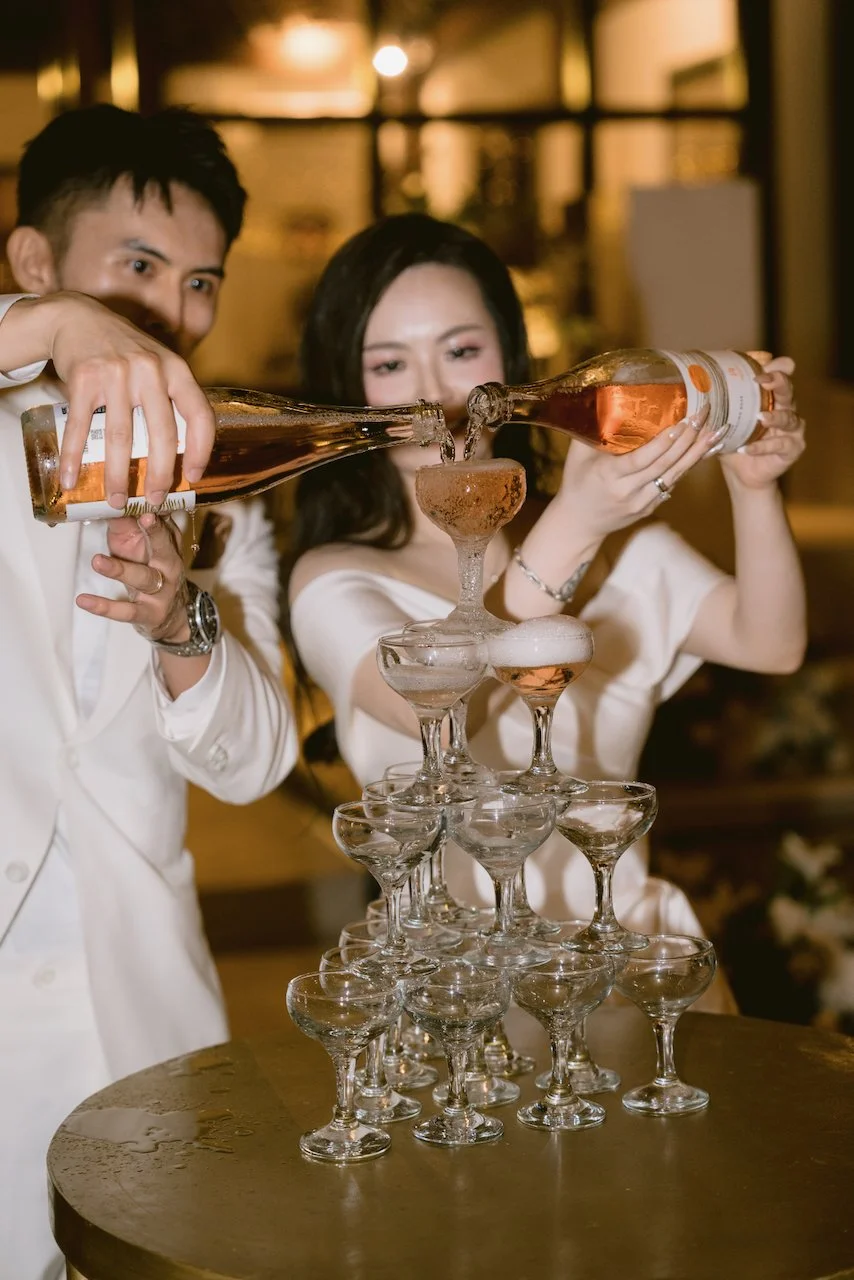 Bride and groom pouring champagne tower at Bali wedding reception