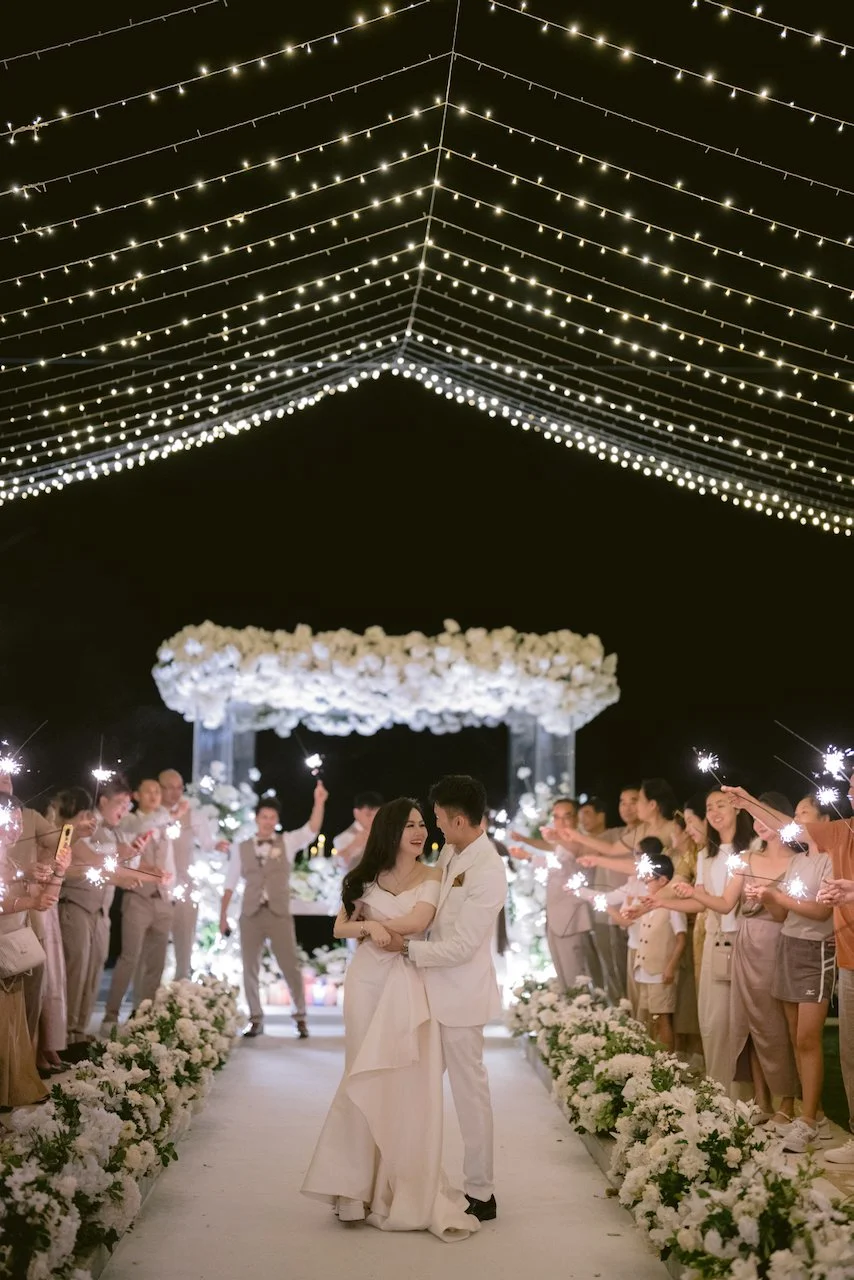 Couple exit with sparklers under fairy lights at Bali villa wedding