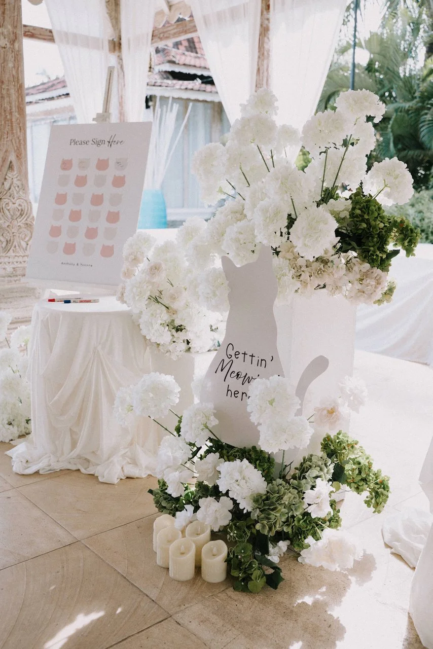 Cat-themed guest book signing table with white florals and a "Gettin' Meow'd" cutout.