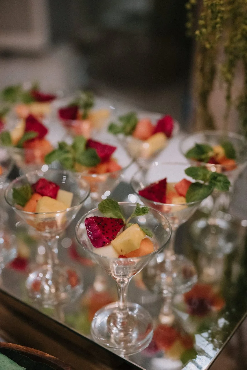 Fresh tropical fruit salad with vibrant dragon fruit served in elegant martini glasses at a Bali wedding reception.