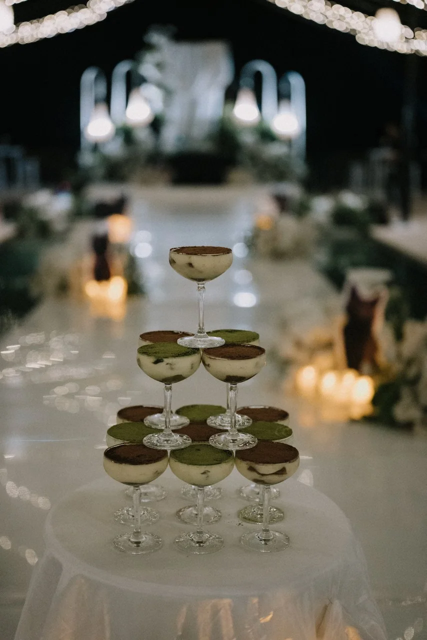 Unique wedding cake alternative featuring a tiered tower of individual tiramisu and matcha dessert cups.
