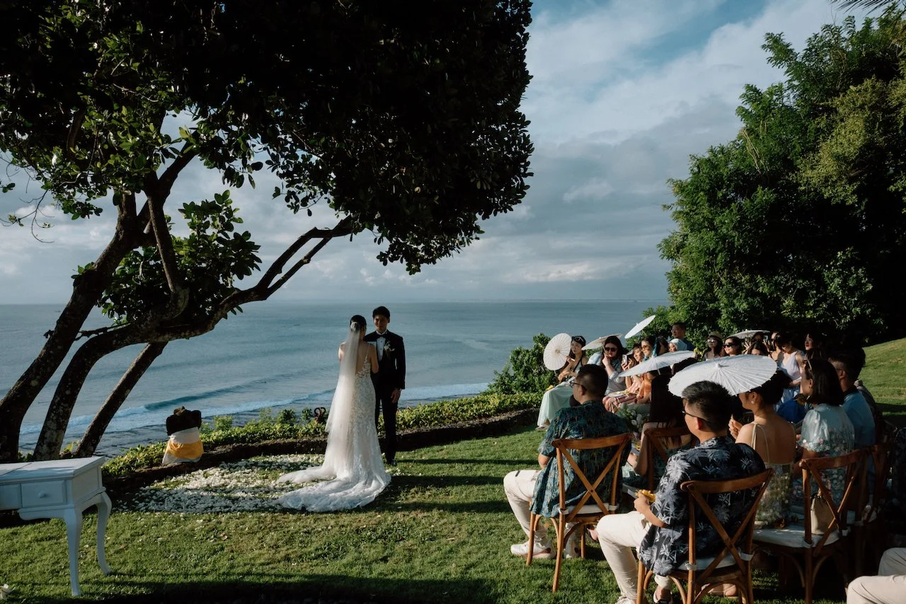 View from behind of a cliffside wedding ceremony at Villa Pemutih.